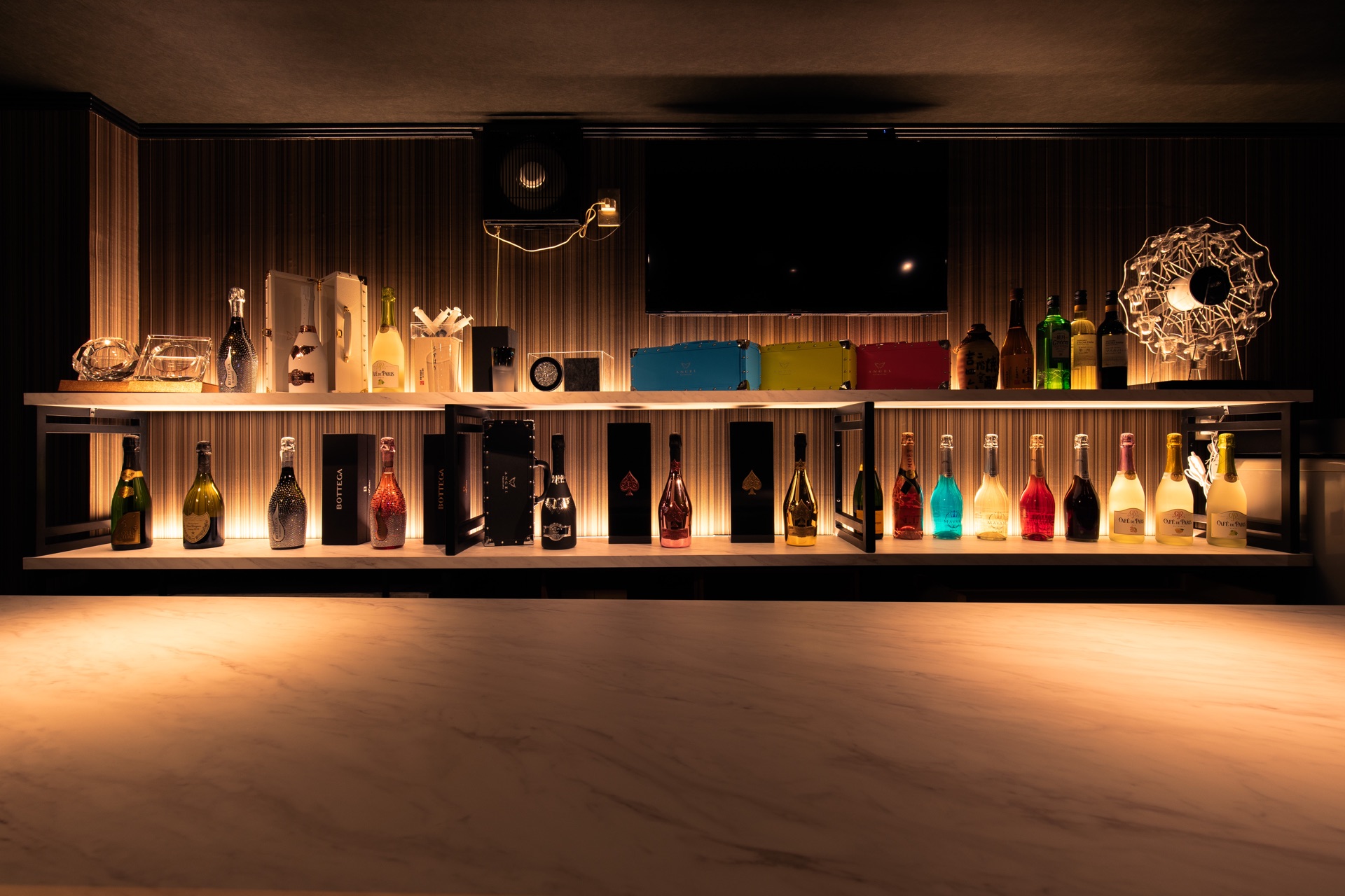 Bar All-in実店舗のボトル棚と白いカウンター